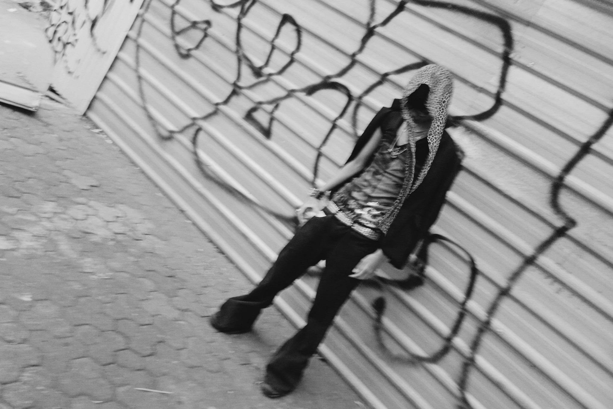 Foto fashion hitam putih Kirei bersandar pada dinding bergaya graffiti