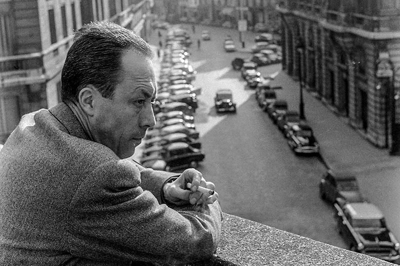 Albert Camus memandang jalan kota dari balkon